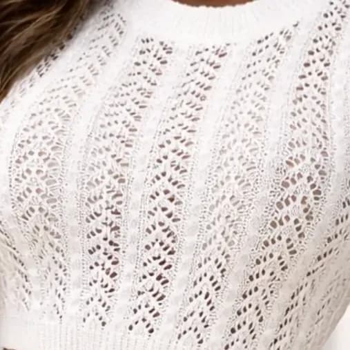 Close crop of an open pointelle knit in ivory, showing the ribbed columns and eyelet pattern