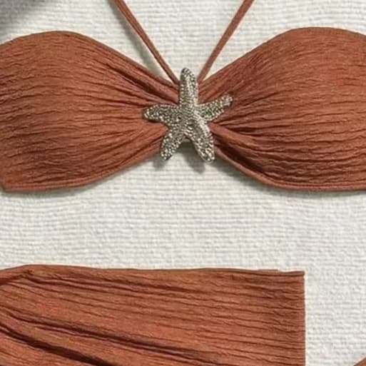 Close crop of a rust-coloured bandeau with a silver starfish ornament set at the centre gather